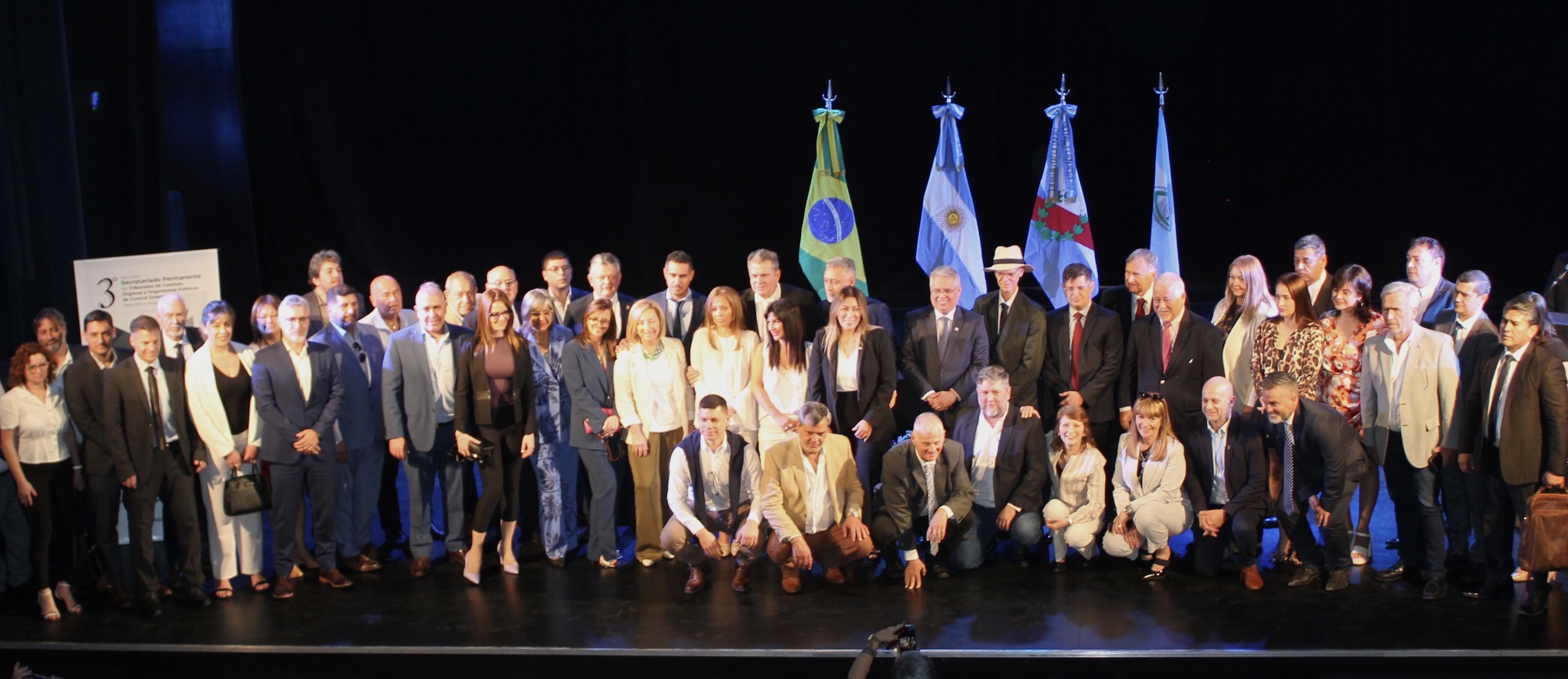 Funcionarios/as participantes del encuentro sobre un escenario