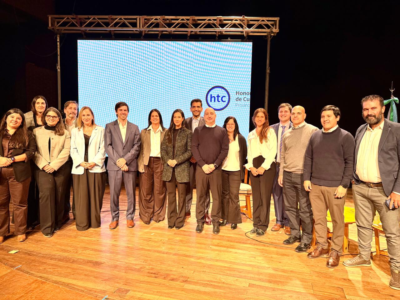 Autoridades del HTC y representantes de OMC sobre un escenario posan mirando al frente
