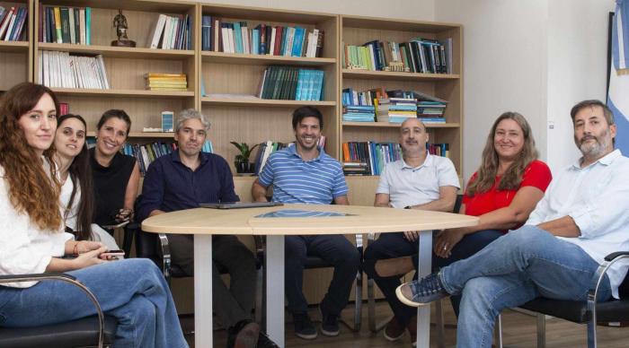 Funcionarios del HTC sentados en una mesa junto al referente de la empresa IRAM