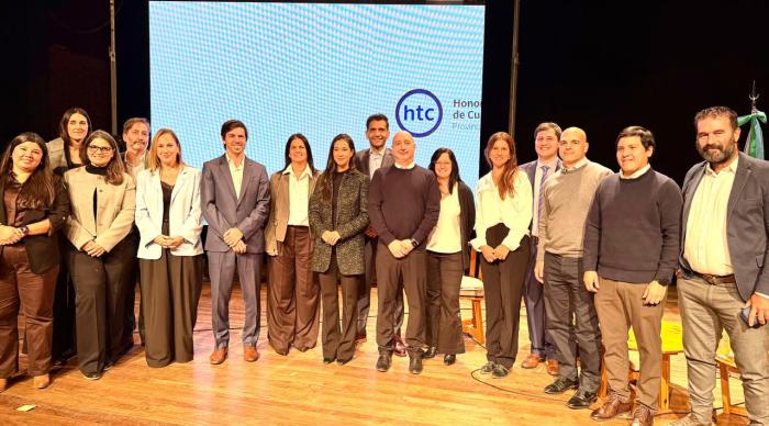 Autoridades del HTC y representantes de OMC sobre un escenario posan mirando al frente